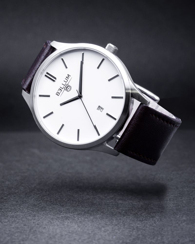 Reloj para hombre marca Bellum, color plata con dial blanco y correa de cuero marrón. Imagen profesional flotando de lado.